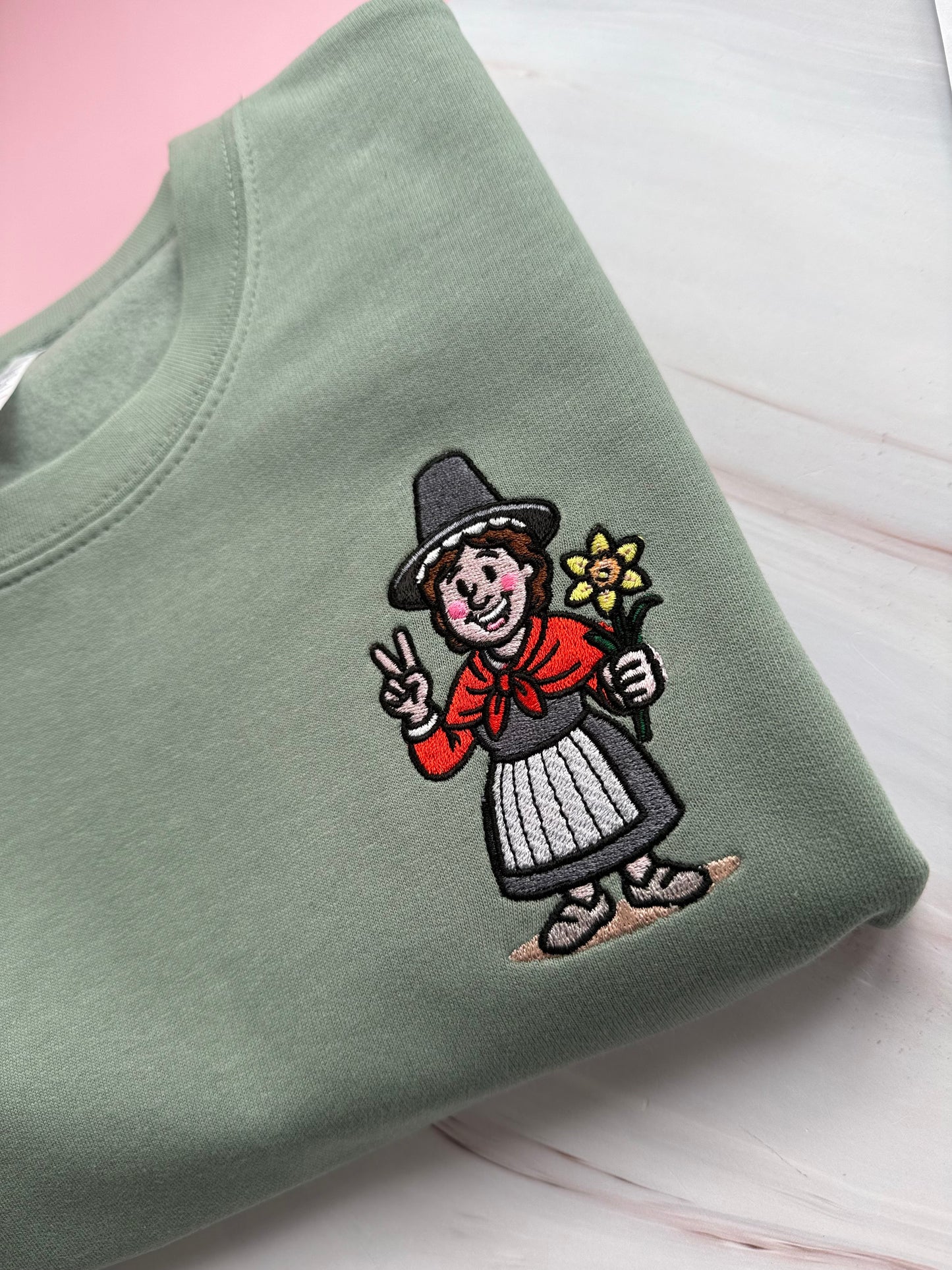 Embroidered Dusty Green jumper with Welsh lady Miri Machno close up 